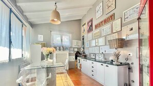 A modern kitchen with a glass dining table, white cabinets, and a red accent wall. - Villa Alice, Menaggio, Italy (Menaggio)