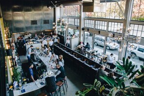 A spacious restaurant with high ceilings, large windows, and a modern industrial design. - Rain Shower, Modern Retreat, Central Location! (Seattle)