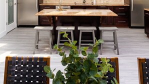A modern kitchen with skylights, stainless steel appliances, and a central island with stools. - Brentwood Pool/Spa Home Close to Everything! (Los Angeles)