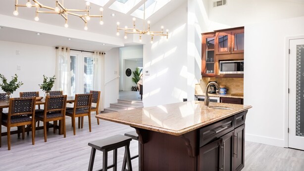 A modern kitchen with a large island, wooden cabinets, and a skylight. - Brentwood Pool/Spa Home Close to Everything! (Los Angeles)