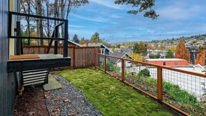 A modern house with a balcony, a wooden fence, and a view of a cityscape. - Lovely condo overlooking the Fremont Bridge (Seattle)