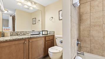 A modern bathroom with a sink, toilet, and bathtub.