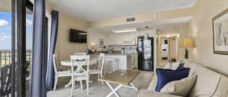 Un apartamento moderno con balcón, comedor, cocina y sala de estar.