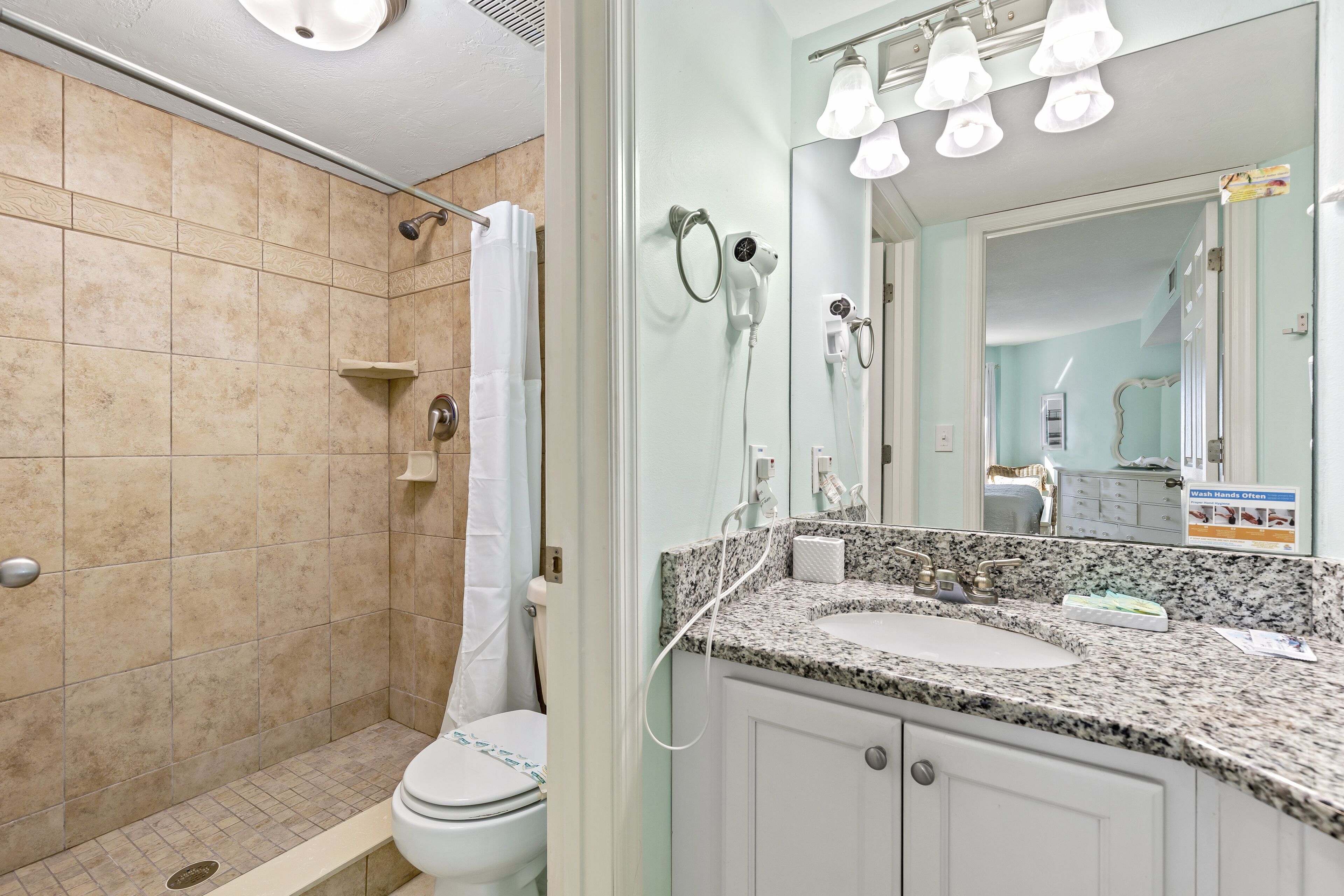 Une salle de bain équipée d’une douche, de toilettes, d’un lavabo et d’un meuble-lavabo.