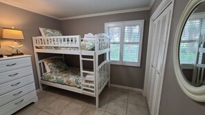 A bunk bed room with a dresser, a window with blinds, and a starfish decoration. - Beach Front~2 BDRM Condo, 2 BA, Pool, 4 Bikes & VIEWS! One Level!  #1F (Hilton Head Island)