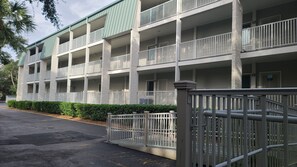 A multi-story hotel with balconies, a gated entrance, and a parking area. - Beach Front~2 BDRM Condo, 2 BA, Pool, 4 Bikes & VIEWS! One Level!  #1F (Hilton Head Island)