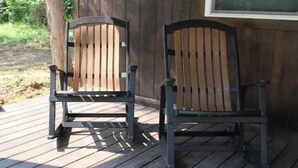 Two wooden chairs on a wooden deck.