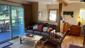 Un salon chaleureux avec un canapé, un fauteuil à bascule, une table basse et une commode en bois.