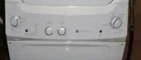 Una lavadora blanca con panel de control y puerta.