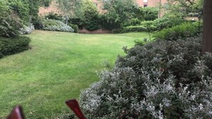 A well-maintained lawn, dense shrubbery, and a multi-story building in the background. - London Central 2 Bathroom Flat with Free Parking (London)