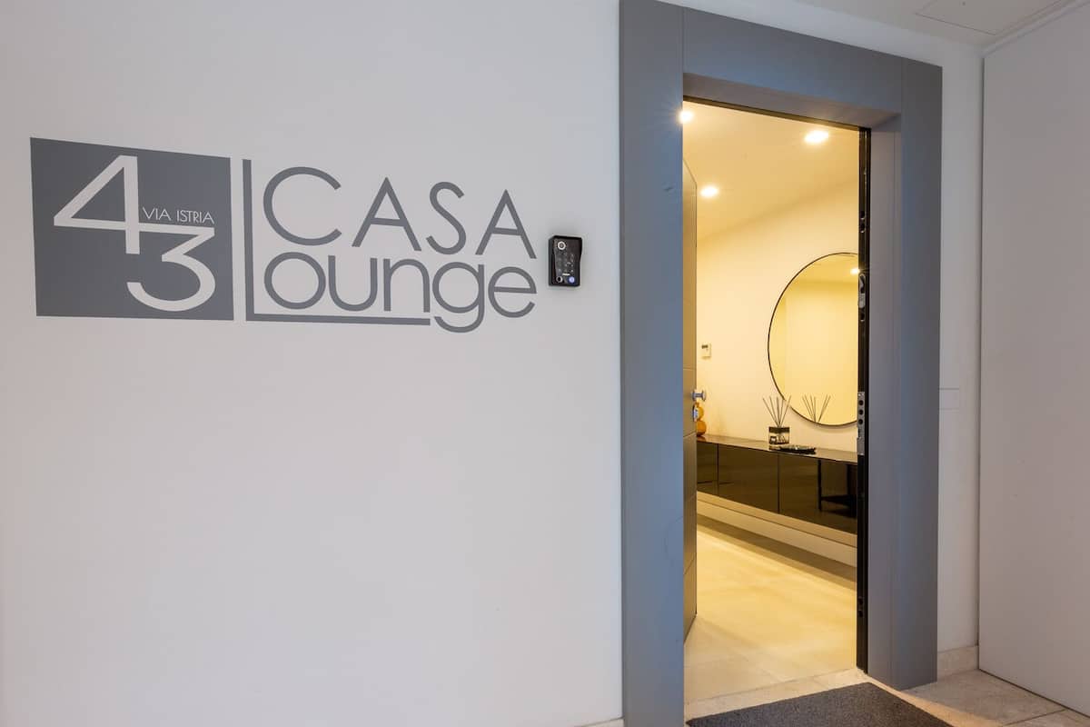 A hallway with a sign for 'Casa Lounge' and a door leading to a bathroom.