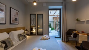 A modern hotel room with a bed, a desk, and a view of the courtyard. - Casa Lounge 43 (Cagliari)