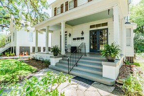 A two-story house with a covered porch, a front door, and a staircase leading to the entrance. - Historic Home in Oakleigh, Sleeps 10, Mardi Gras (Mobile)