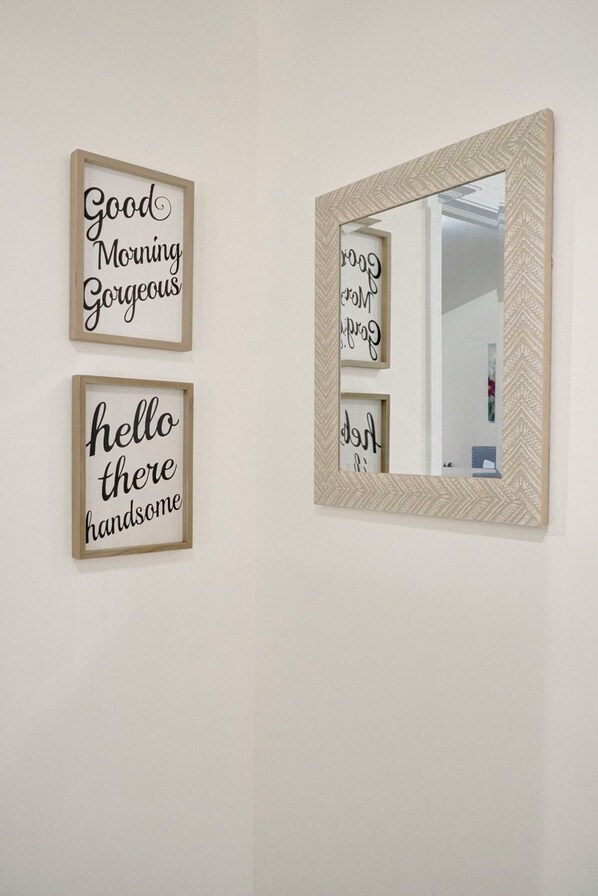 Trois panneaux encadrés, affichant des phrases motivantes, sont accrochés à un mur uni.