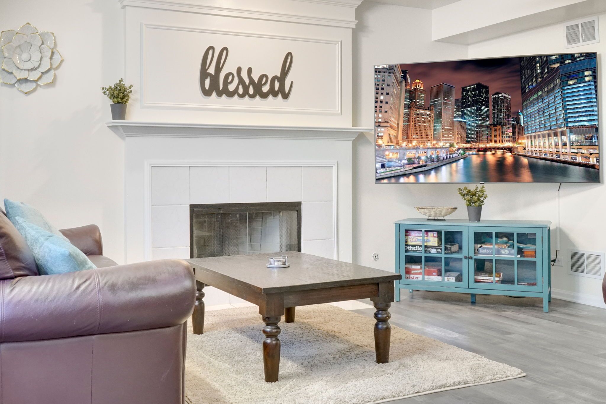 A living room with a fireplace, a sofa, a coffee table, a TV, and a cabinet.