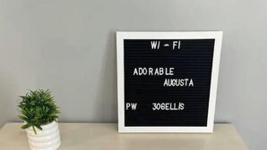 Une console en bois surmontée d’une plaque noire portant l’inscription : « W/ - FI ADORABLE AUGUSTA PW 306ELLIS ».