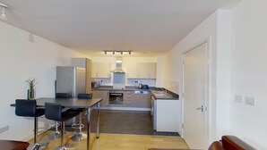 Cocina compacta con comedor, que incluye refrigerador, microondas, horno y pileta.