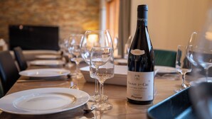 A dining table set with plates, wine glasses, and a bottle of wine. - Chalet Gaïla spacious chalet in Les Allues next to the gondola (Meribel Les Allues)