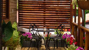 Relax on the deck with a meal or social gathering, surrounded by lush greenery and a scenic view.