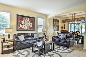 Relax in this stylish living room with two comfortable sofas, a glass coffee table, and elegant artwork on the walls.