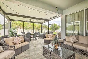 Relax in a serene outdoor space with wicker sofas, patterned cushions, and a glass coffee table.