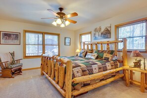 A bedroom with a wooden bed frame, a rocking chair, and a ceiling fan. - Mountain-View Murphy Cabin w/ Shared Fire Pit (Murphy)