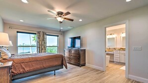 Ein Schlafzimmer mit Bett, Kommode und Deckenventilator.