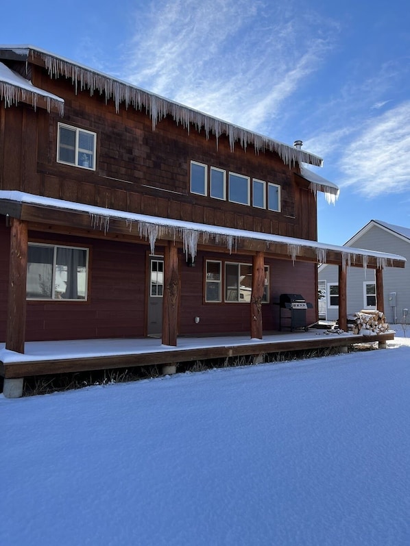 A two-story wooden cabin with a covered porch and a chimney.