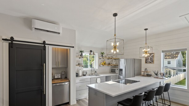 A modern kitchen with a central island, bar stools, and pendant lighting. - NEW!!! Modern cottage and perfect location! (Bluffton)