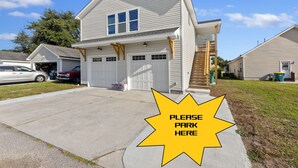 A two-story house with a garage, a driveway, and a 'Please Park Here' sign. - NEW!!! Modern cottage and perfect location! (Bluffton)