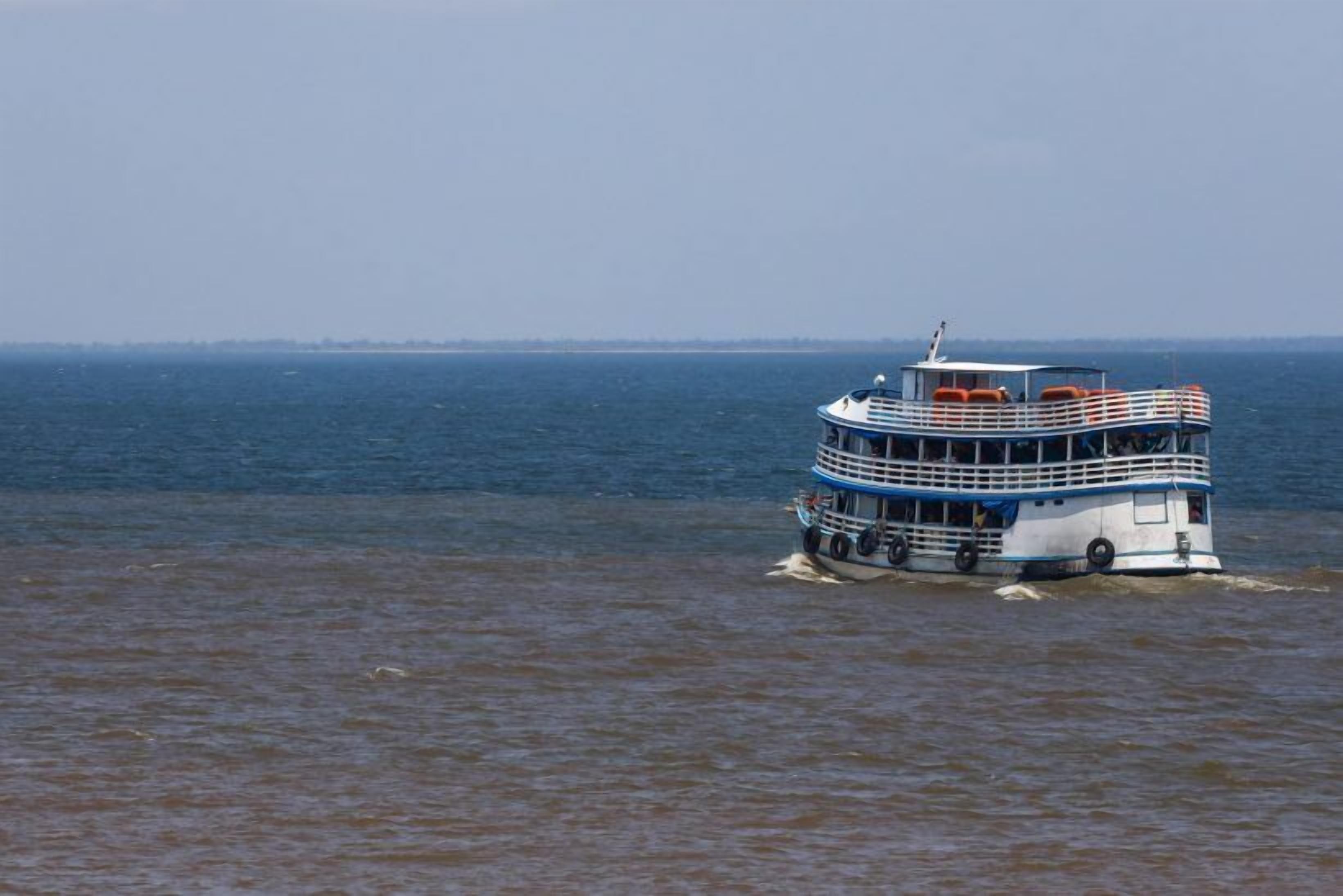 Un bateau à plusieurs ponts, aux couleurs bleu et blanc, équipé de plusieurs canots de sauvetage et doté d’une structure de cabine.