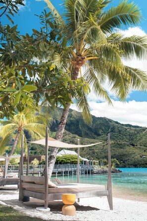 Privat strand, hvit sand, solsenger og parasoller
