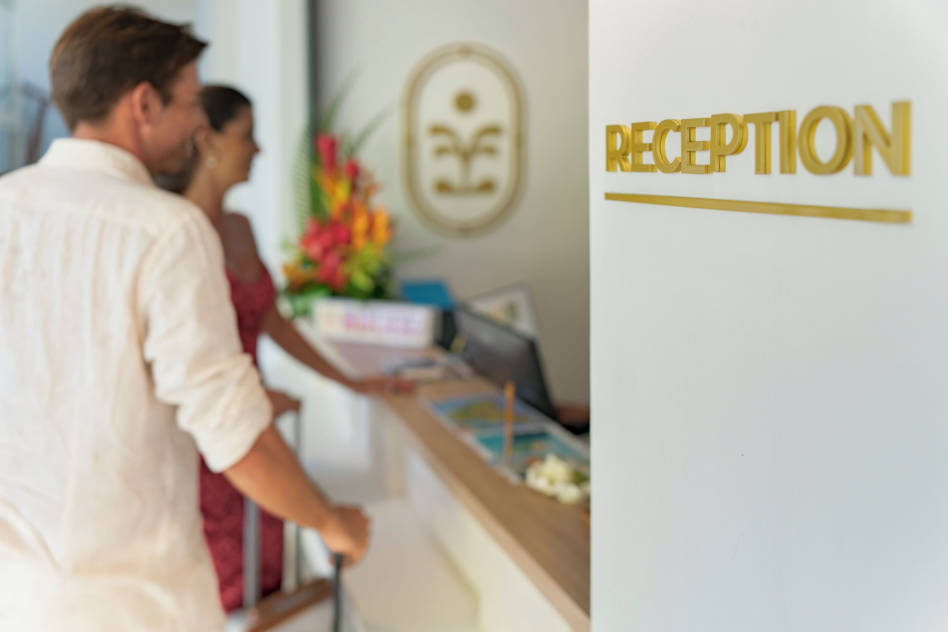 A reception area with a reception desk, a framed logo on the wall, and a sign that reads "RECEPTION".