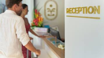 A reception area with a reception desk, a framed logo on the wall, and a sign that reads "RECEPTION".