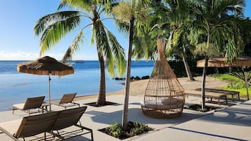 Playa privada, arena blanca, sillas reclinables de playa, sombrillas