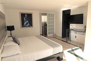 A hotel room with a bed, a desk, a TV, and a painting on the wall. - Hotel Grand Vista Cuernavaca (Cuernavaca)