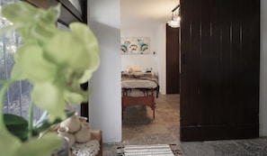 A bedroom with a bed, a painting on the wall, and a door leading to another room. - Hotel Grand Vista Cuernavaca (Cuernavaca)