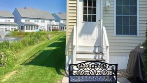 En boligbygning med hvid facade, en hoveddør og en lille altan.