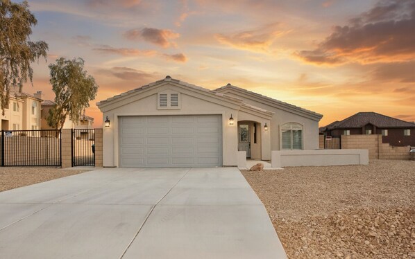 A residential house with a garage, a driveway, and a gravel front yard.