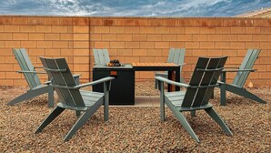 Un espace extérieur aménagé avec un mur en briques, une table et quatre chaises.