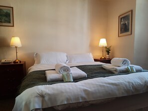 Habitación doble | Tabla de planchar con plancha y ropa de cama