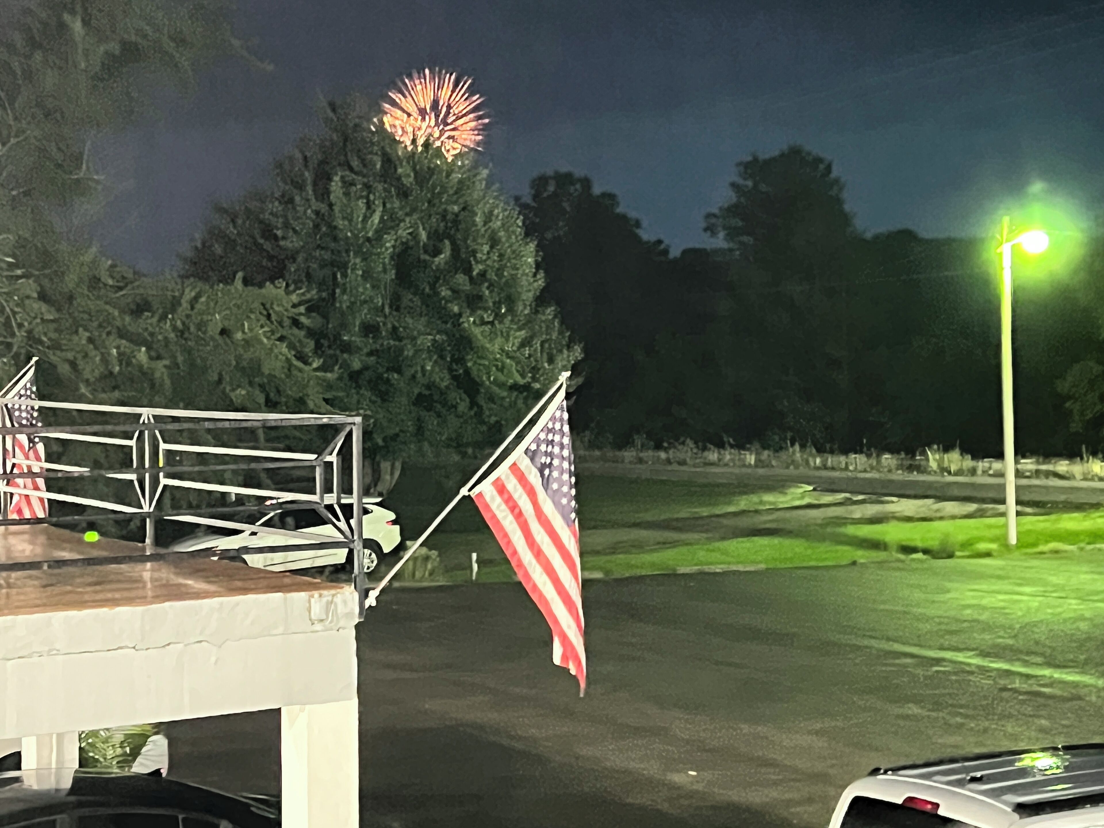 Un campo de golf de noche con un asta y una bandera.