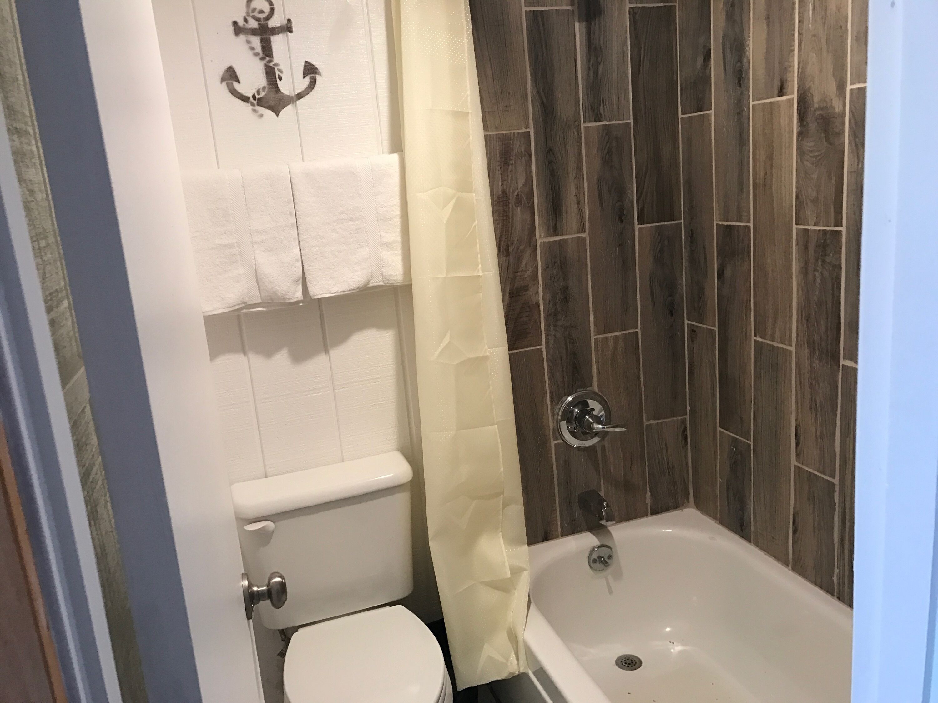 A bathroom with a toilet, a bathtub, and a shower curtain.