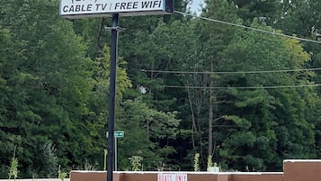 Placa de motel com o nome 'Falls of Rough Hotel' e comodidades como TV a cabo e acesso Wi-Fi gratuito.
