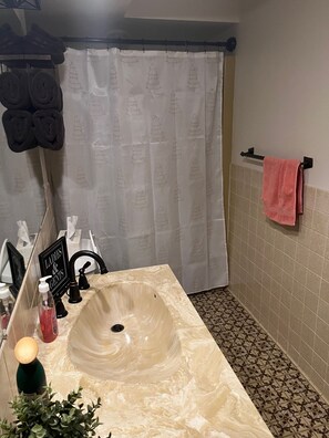 Bañera con ducha, secador de pelo, toallas, papel higiénico