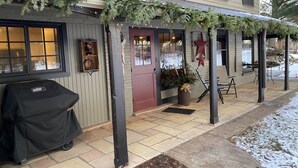 Un bâtiment doté d’un porche abrité, d’un barbecue et d’un sapin de Noël.
