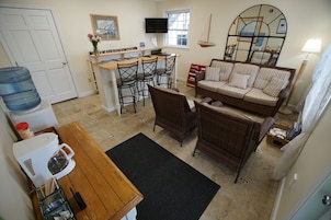 Cocina compacta con zona de comedor, un sofá y una televisión.