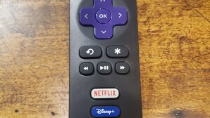 Un control remoto con botones para Netflix, Disney+, Apple TV+, HBO Max y TCL Roku TV.