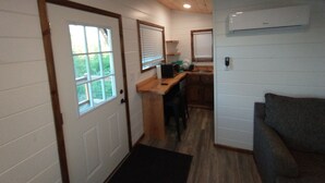 A compact kitchen with wooden cabinets, a countertop, and a window.