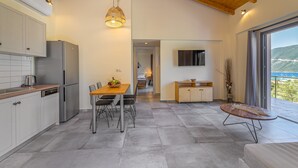 A modern kitchen with a dining area, a wooden ceiling, and a view of the outdoors. - Gyri Villa, overlooking Vassiliki bay (Lefkada)